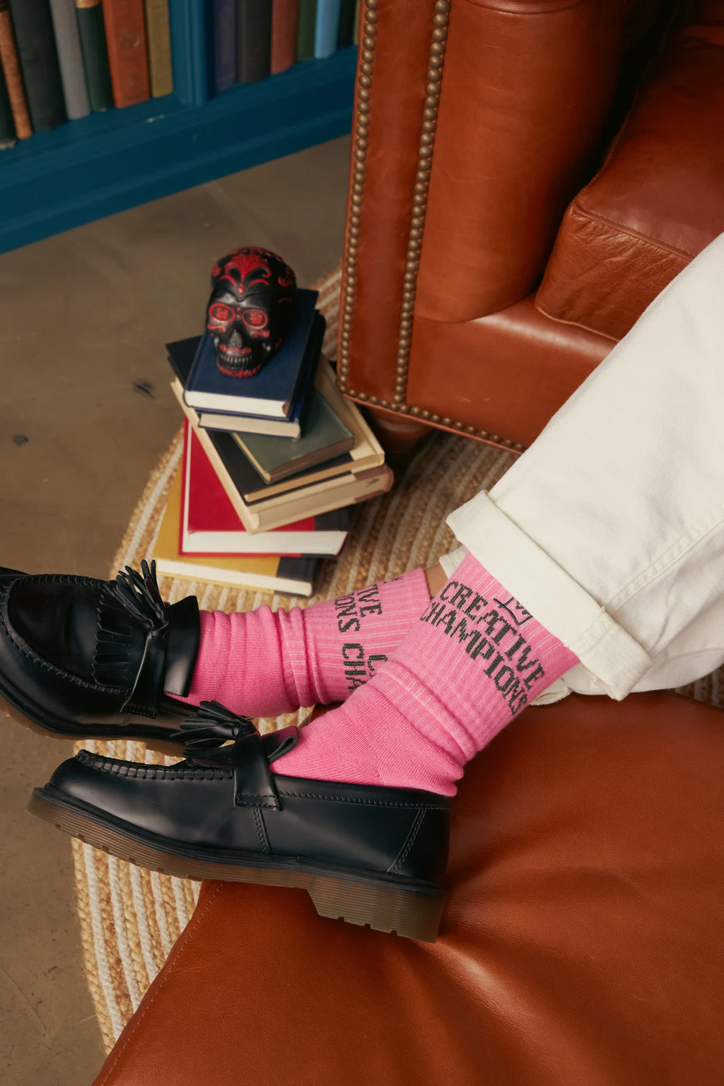 Pink Creative Champions socks worn with black loafers and cream trousers