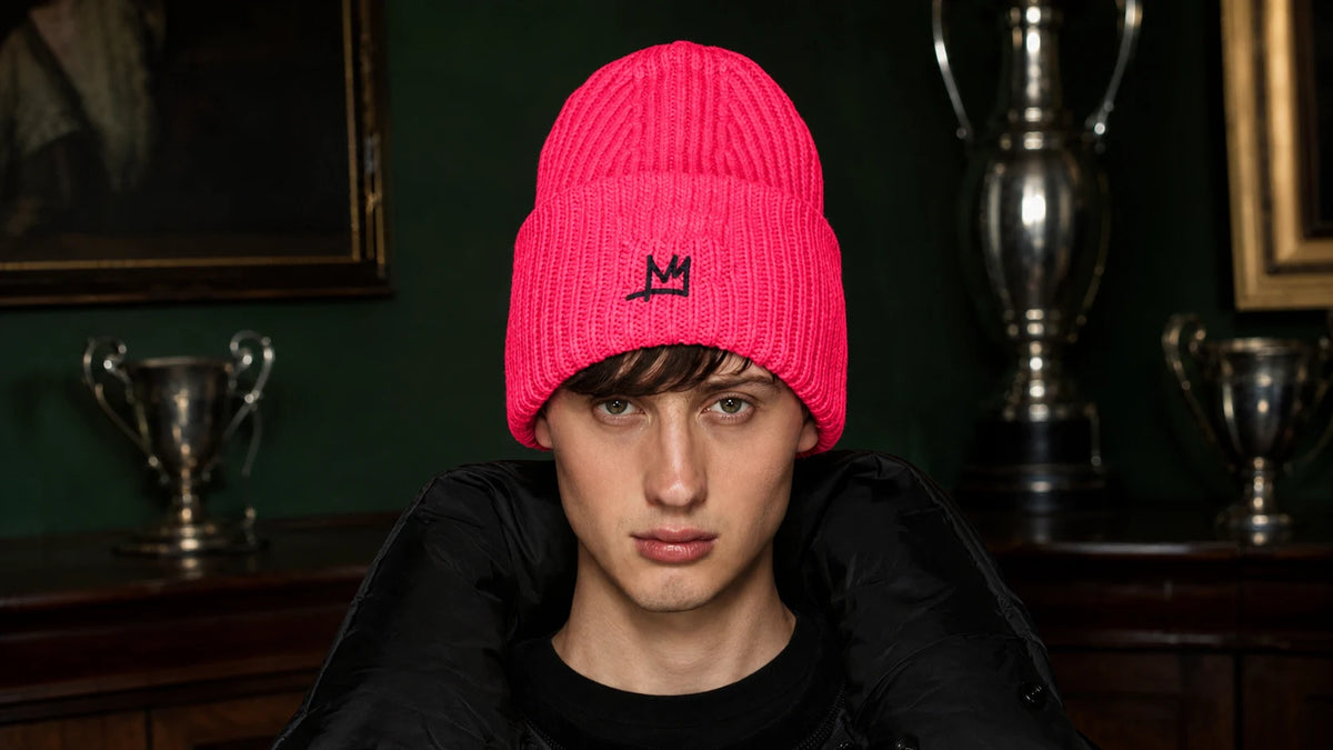 Model wearing the hot-pink ELEANOR beanie with an embroidered black crown