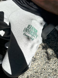 Detail of green Eleanor University Winners Only embroidery on grey sweatpants